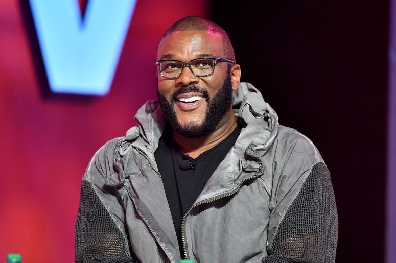 Fans call for Tyler Perry to hire more black writers. Tyler Perry poses smiling on stage at Essence Festival 2019.