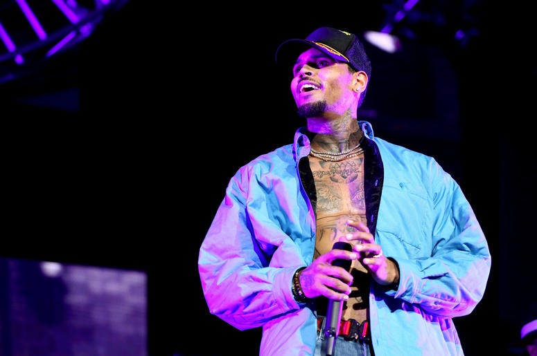 Chris Brown may be expecting a second child. Chris Brown holds mircrophone and smiles while performing at 2018 BET Experience.