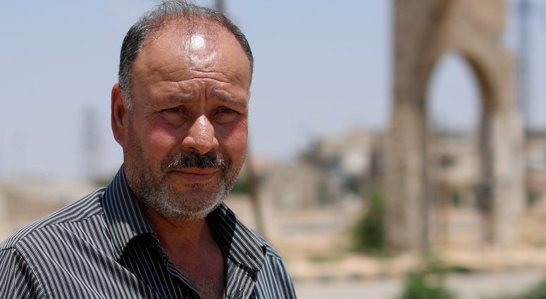 In this Tuesday, July 17, 2018, photo, Col. Omar Melhem, 51, who defected from the Syrian army defector and once commanded a rebel faction of some 3,000 fighters speaks during an interview with The Associated Press in the central Syrian town of Talbiseh,