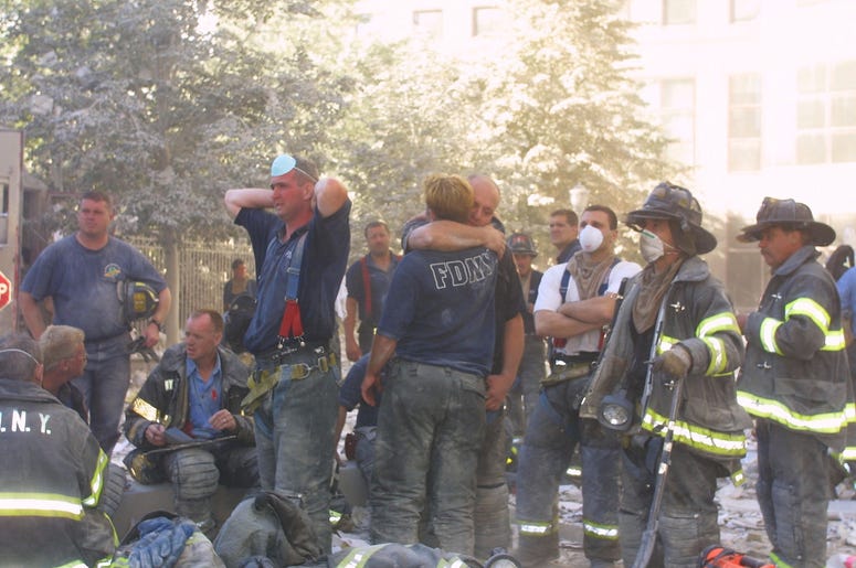 New York City firefighters hug each other during rescue operations at the World Trade Center after two hijacked planes crashed into the Twin Towers September 11, 2001 in New York. New York City firefighters hug each other during rescue operations at the World Trade Center after two hijacked planes crashed into the Twin Towers September 11, 2001 in New York. (Photo by Ron Agam/Getty Images)