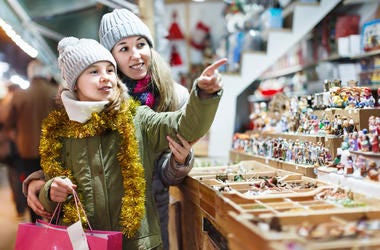 Girl with woman choosing Christmas gifts for family