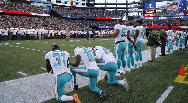 Dolphins players kneeling