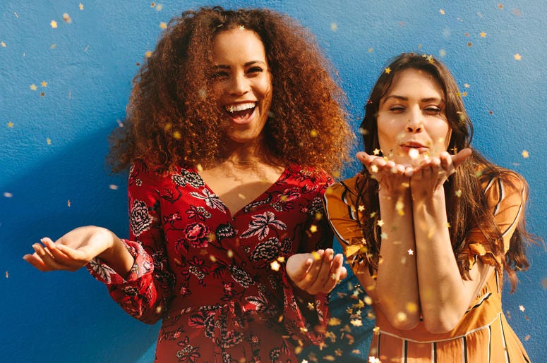 Two Women Blowing Glitter two women blowing glitter