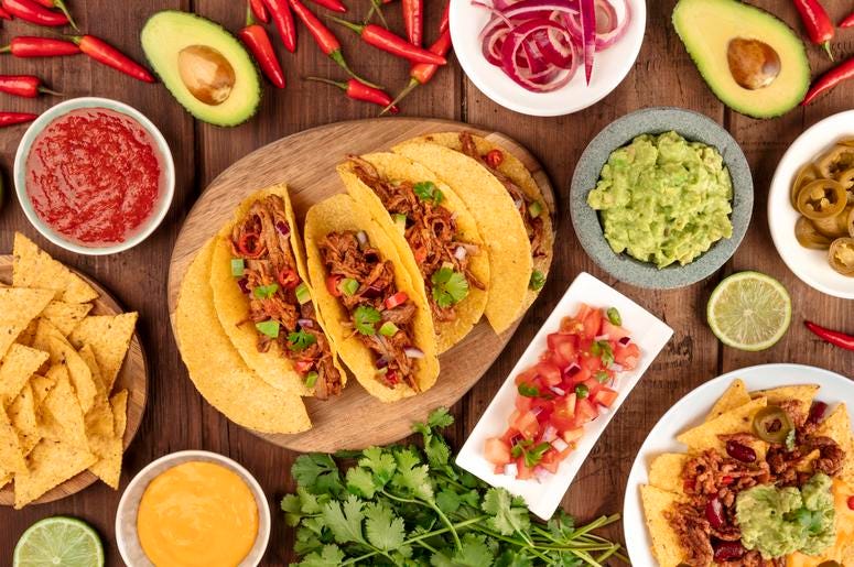 A plate of tacos and condiments