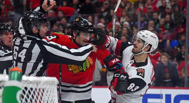 Blackhawks defenseman Dennis Gilbert (39) and Coyotes right wing Conor Garland (83) fight. Blackhawks defenseman Dennis Gilbert (39) and Coyotes right wing Conor Garland (83) fight.