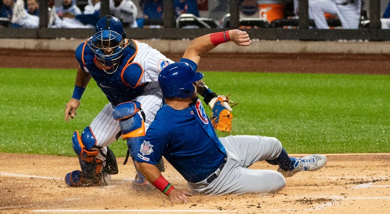 Cubs left fielder Kyle Schwarber (12) slides under the tag by Mets catcher Wilson Ramos (40) and scores a run. Cubs left fielder Kyle Schwarber (12) slides under the tag by Mets catcher Wilson Ramos (40) and scores a run.