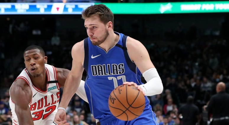 Mavericks forward Luka Doncic (77) drives past Bulls guard Kris Dunn. Mavericks forward Luka Doncic (77) drives past Bulls guard Kris Dunn.