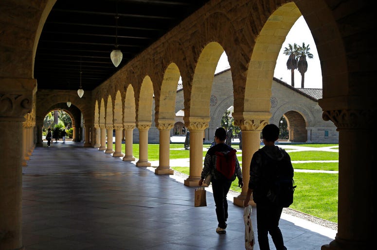 In this March 14, 2019, file photo, people walk on the Stanford University campus in Santa Clara, Calif. NerdWallet_College_Admission
