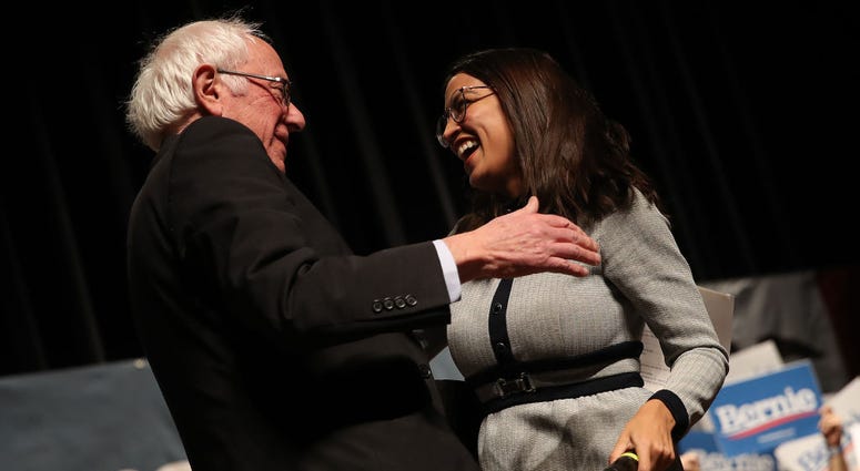 Democratic presidential candidate Sen. Bernie Sanders (I-VT) is greeted by Rep. Alexandria Ocasio-Cortez (D-NY) after she introduced him at a campaign event at the Ames City Auditorium on January 25, 2020 in Ames, Iowa.