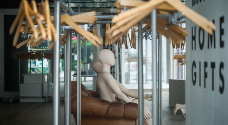 Mannequins and empty clothes rails are seen in a permanently closed store on July 27, 2020.