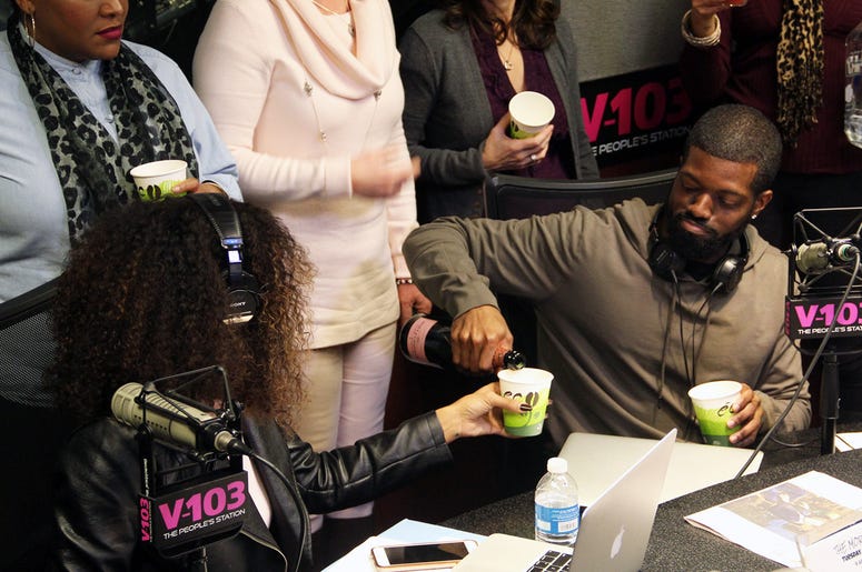 JR of The Morning Culture pouring Moet Champagne for co-host Jade Novah JR of The Morning Culture pouring Moet Champagne for co-host Jade Novah