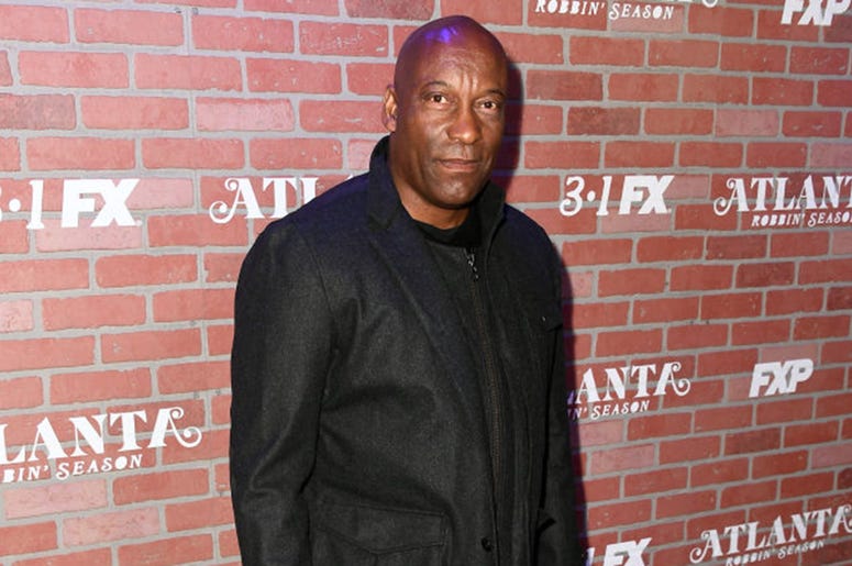 John Singleton attends the premiere for FX's "Atlanta Robbin' Season" at The Theatre at Ace Hotel on February 19, 2018 in Los Angeles, California. John Singleton attends the premiere for FX's "Atlanta Robbin' Season" at The Theatre at Ace Hotel on February 19, 2018 in Los Angeles, California.