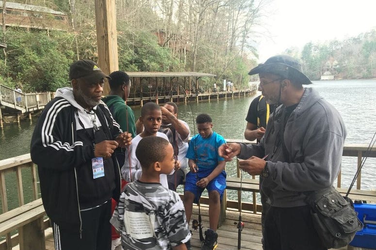 Officer Bruce Griggs (l) observes as the boys receive fishing lessons at YMCA Camp High HarboUr in Cartersville GA Officer Bruce Griggs (l) observes as the boys receive fishing lessons at YMCA Camp High HarboUr in Cartersville GA