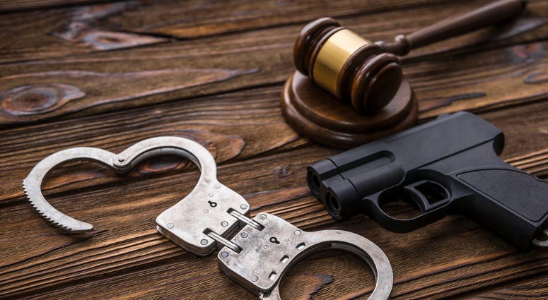 A gavel, gun and handcufffs