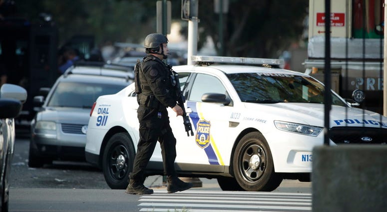 A massive police presence is set up outside a house as they investigate an active shooting situation, Wednesday, Aug. 14, 2019, in the Nicetown neighborhood of Philadelphia. (AP Photo/Matt Rourke)