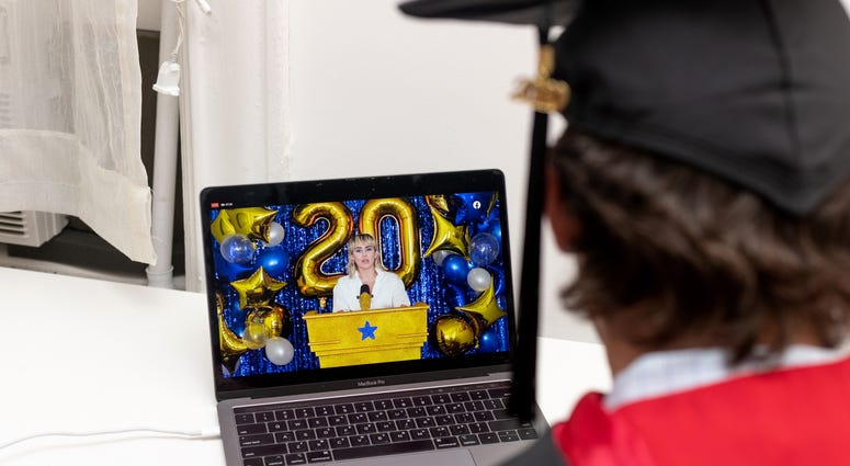A recent graduate watches Miley Cyrus perform during a virtual graduation ceremony held by Facebook from his laptop on May 15, 2020 in New York City.