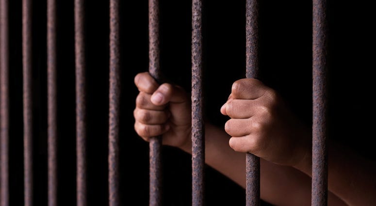 Hands on prison bars