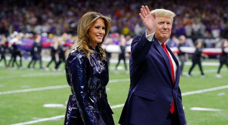 NEW ORLEANS, LOUISIANA - JANUARY 13: (L-R) First Lady Melania Trump and U.S. President Donald Trump wave prior to the College Football Playoff National Championship game between the Clemson Tigers and the LSU Tigers at Mercedes Benz Superdome. Donald Trump