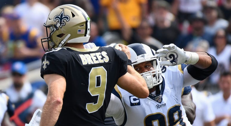 Los Angeles Rams defensive tackle Aaron Donald (99) charges toward New Orleans Saints quarterback Drew Brees (9) after a pass pay in the 1st quarter at Los Angeles Memorial Coliseum. Brees would leave the game with a hand injury after the play.