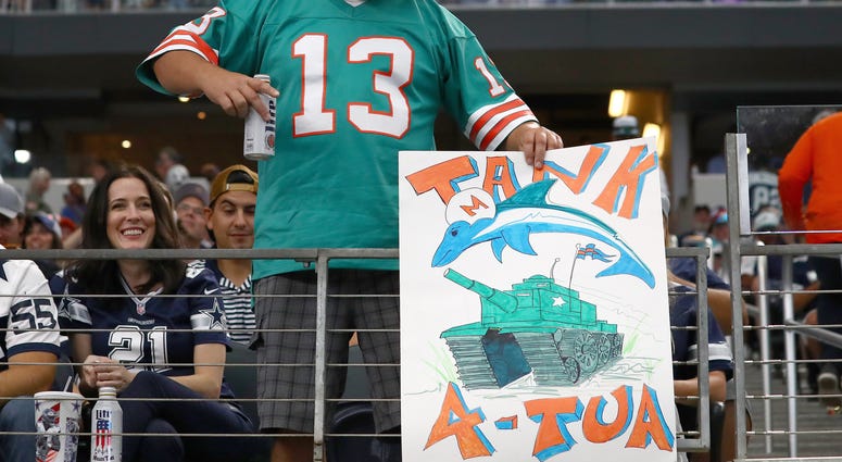 Miami Dolphins fan holds a tanking sign during the game against the Dallas Cowboys at AT&T Stadium.