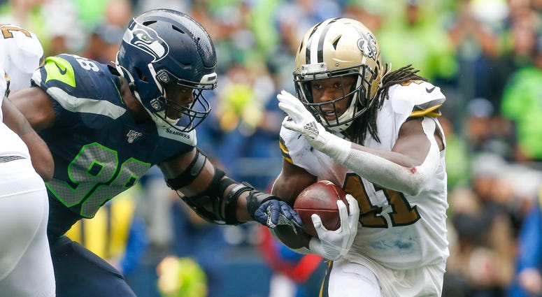 New Orleans Saints running back Alvin Kamara (41) rushes against Seattle Seahawks defensive end Rasheem Green (98) during the fourth quarter at CenturyLink Field.