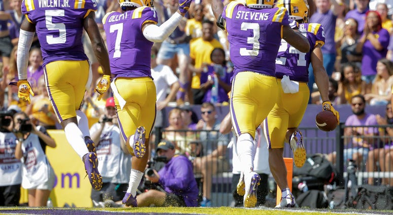 LSU Tigers cornerback Derek Stingley Jr. (24) celebrates with teammates after intercepting a pass against the Utah State Aggies during the first half at Tiger Stadium.