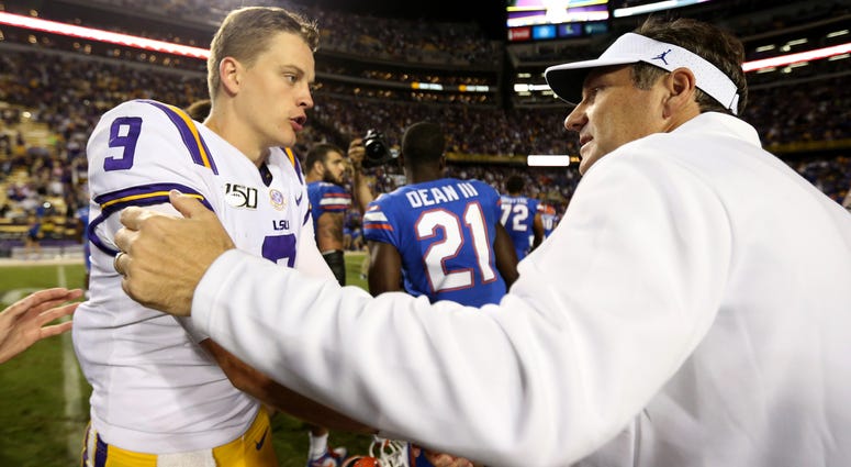 LSU Tigers quarterback Joe Burrow (9) shakes hands with Florida Gators head coach Dan Mullen at the end of their game at Tiger Stadium.