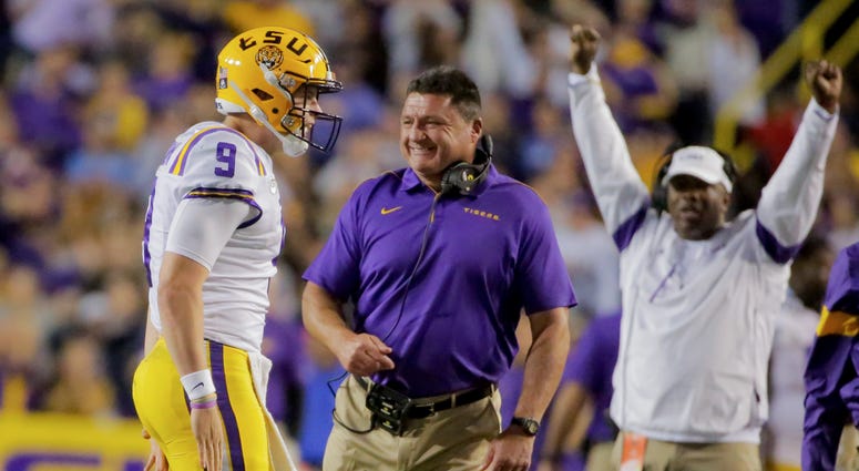 LSU Tigers quarterback Joe Burrow (9) celebrates with head coach Ed Orgeron during the fourth quarter against the Florida Gators at Tiger Stadium.