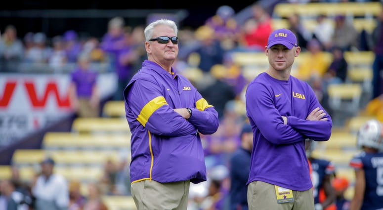 LSU Tigers offensive coordinator Steve Ensminger and passing game coordinator Joe Brady (right) watch during warm ups prior to kickoff against the Auburn Tigers at Tiger Stadium.