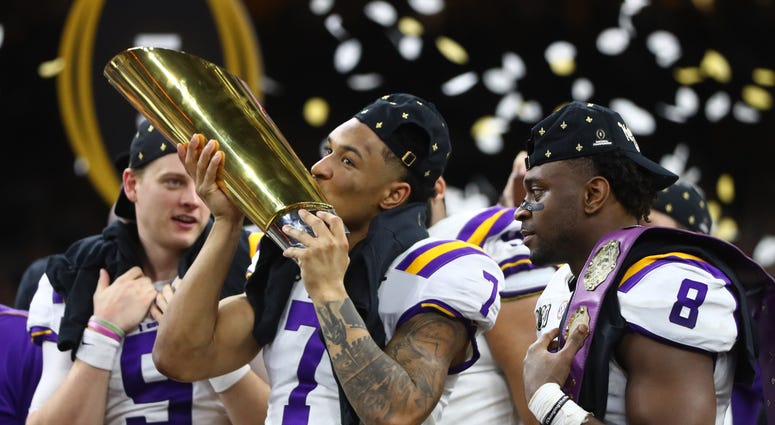 LSU Tigers safety Grant Delpit (7) kisses the national championship trophy after defeating the Clemson Tigers in the College Football Playoff national championship game at Mercedes-Benz Superdome.