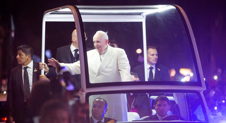 Pope Francis waves to the crowd that waited hours for him near where the Pope is staying at the Vatican diplomatic mission during his inaugural visit to Mexico.