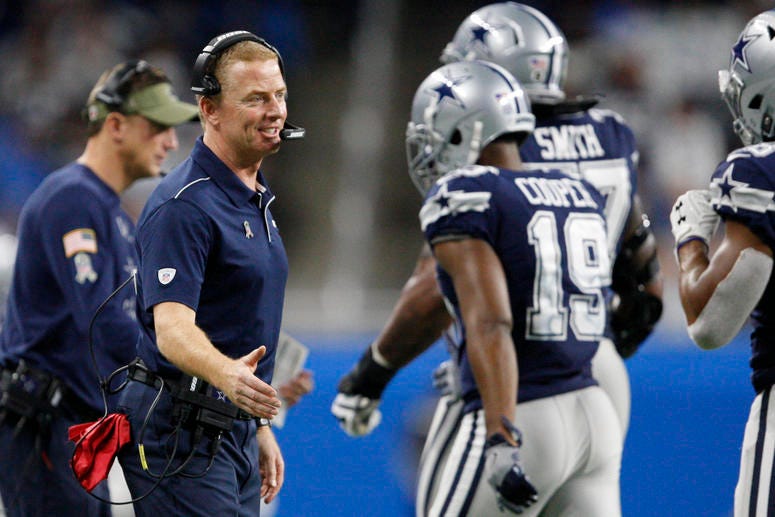Dallas Cowboys head coach Jason Garrett greets offensive tackle Tyron Smith (77) and wide receiver Amari Cooper (19) as they walk to the bench during the fourth quarter against the Detroit Lions at Ford Field.