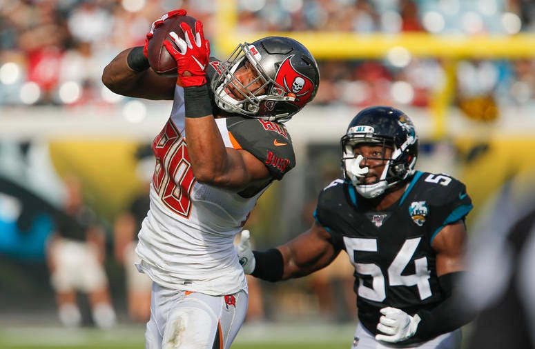Tampa Bay Buccaneers tight end O.J. Howard (80) catches a pass as Jacksonville Jaguars linebacker Donald Payne (54) defends during the second quarter at TIAA Bank Field.