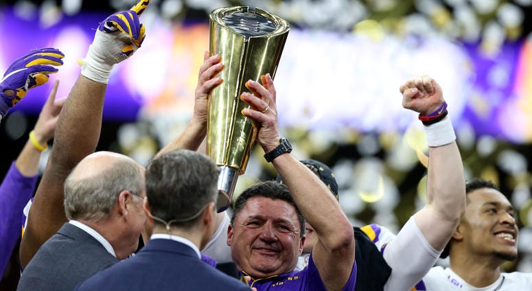 NEW ORLEANS, LOUISIANA - JANUARY 13: Head coach Ed Orgeron of the LSU Tigers and Joe Burrow #9 of the LSU Tigers celebrate with the trophy after defeating the Clemson Tigers 42-25 in the College Football Playoff National Championship game. lsuntrophy