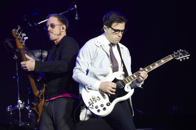 Scott Shriner and Rivers Cuomo of Weezer perform onstage during KROQ Almost Acoustic Christmas 2017 Scott Shriner and Rivers Cuomo of Weezer perform onstage during KROQ Almost Acoustic Christmas 2017