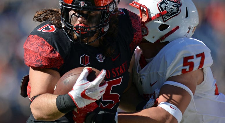 Nov 24, 2017; San Diego, CA, USA; San Diego State Aztecs fullback Nick Bawden (15) is defended by New Mexico Lobos linebacker Everett Powell (57) during the first quarter at SDCCU Stadium.