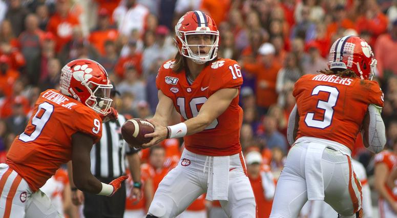 Clemson Tigers quarterback Trevor Lawrence (16) hands the ball off to running back Travis Etienne (9) against the Wake Forest Demon Deacons during the first quarter at Clemson Memorial Stadium.