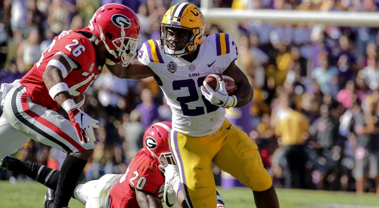 Oct 13, 2018; Baton Rouge, LA, USA; LSU Tigers running back Clyde Edwards-Helaire (22) break away from Georgia Bulldogs defensive back Tyrique McGhee (26) and defensive back J.R. Reed (20) during the second quarter at Tiger Stadium. Mandatory Credit: Deri